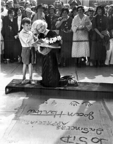 Harlow with a young fan outside of Grauman's Chinese Theater in 1933.