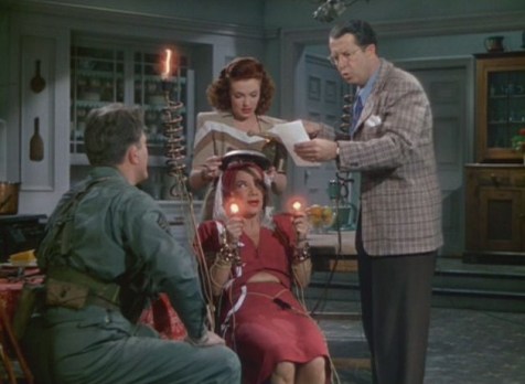Due to Carmen Miranda's short wave radio tooth-she is being used to send Morse Code. Also pictured-Michael O'Shea, Vivian Blaine, Phil Silvers. (Comet Over Hollywood/Screen cap by Jessica P.)