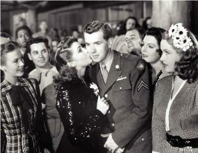 Slim (Hutton) receives a kiss from his actress crush Joan Leslie at the Hollywood Canteen.