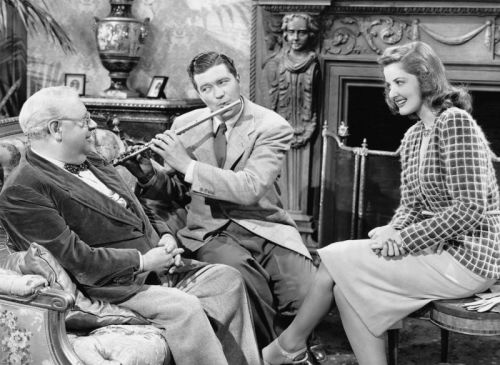 Dennis Morgan shows S.Z. Sakall and Martha Vickers how to play swing on the flute. 