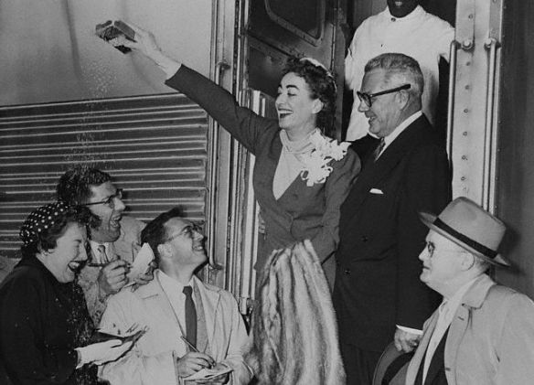 Joan Crawford throwing rice with new husband Alfred Steele. Crawford said Youth Dew helped her attract him.