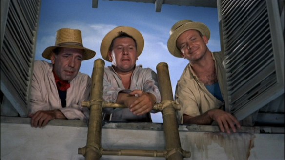 The three convicts watch the family from the roof.