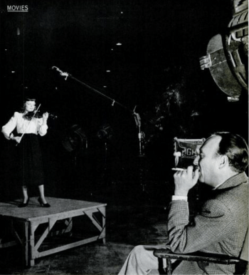 Marcia Van Dyke plays the violin for producer Joe Pasternak. LIFE photo by Johnny Florea (Scan by Comet Over Hollywood)